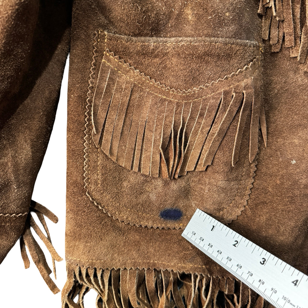 Close up of fringed pocket with small blue mark on brown suede jacket