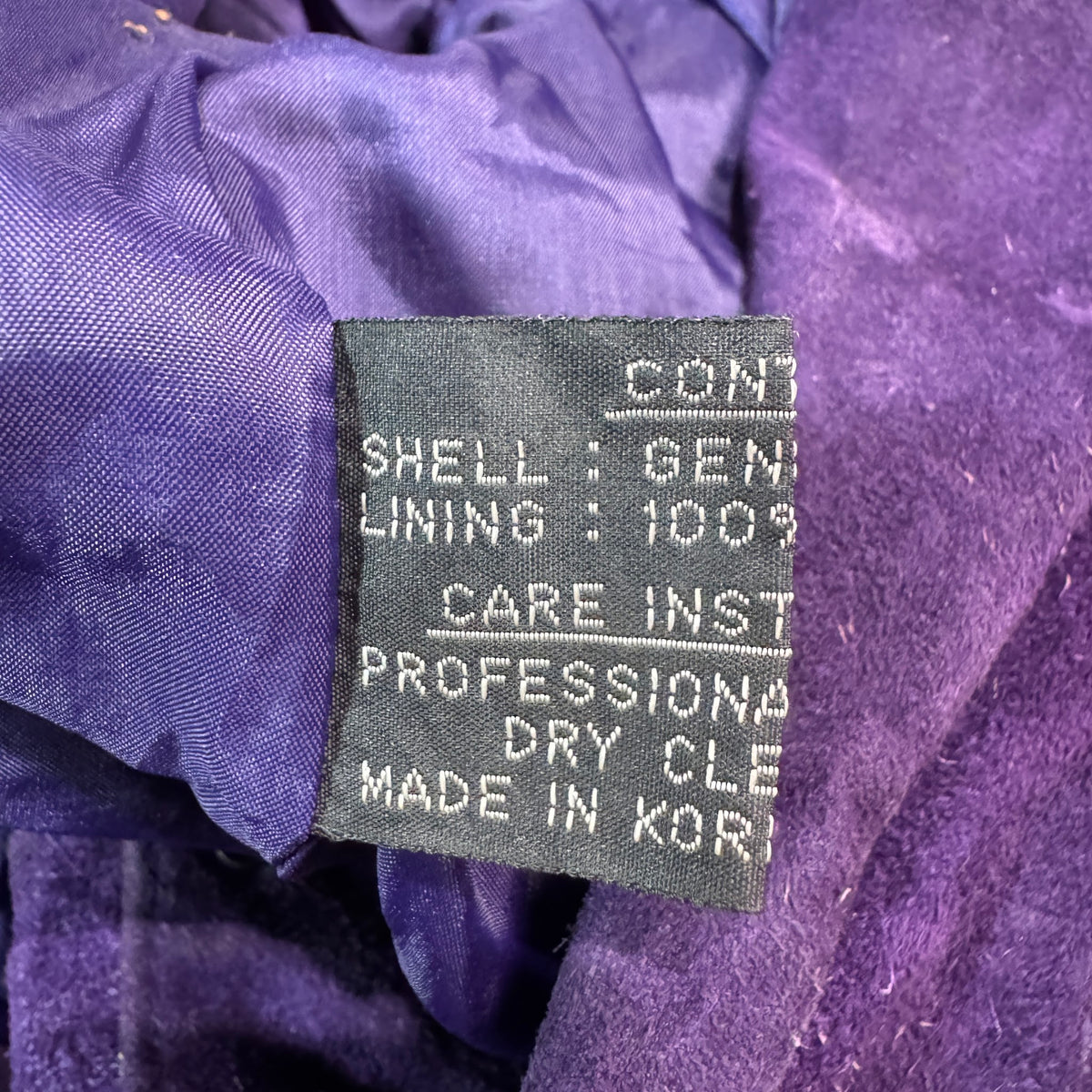 Care and content tag inside purple suede jacket
