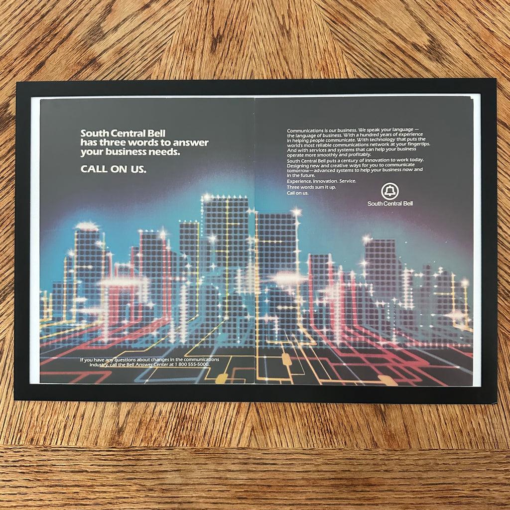 Framed vintage South Central Bell double page magazine ad with neon cityscape