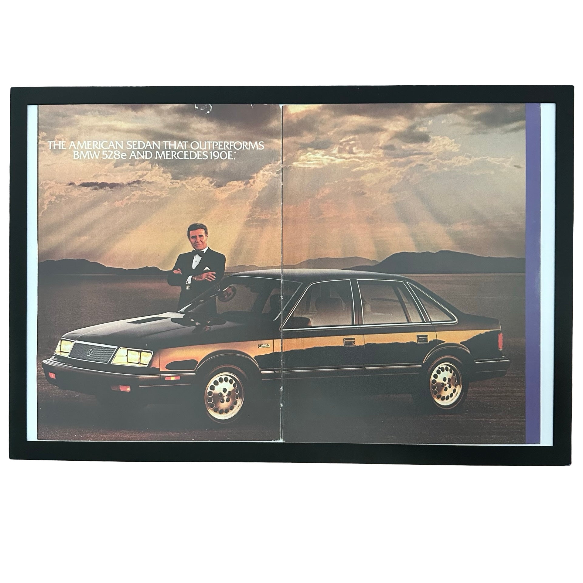 Framed vintage Chrysler LeBaron double page magazine ad with Ricardo Montalban on white background