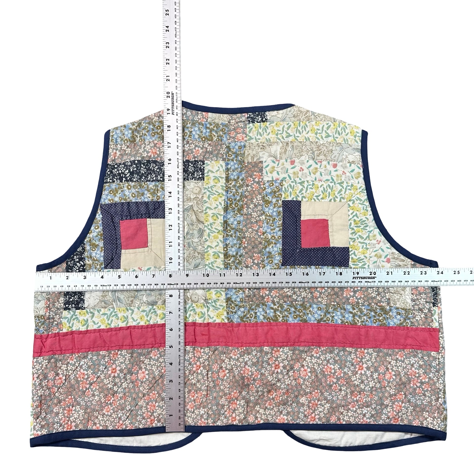 Blue Calico Log Cabin XL quilted vest rework, tape measure across the chest