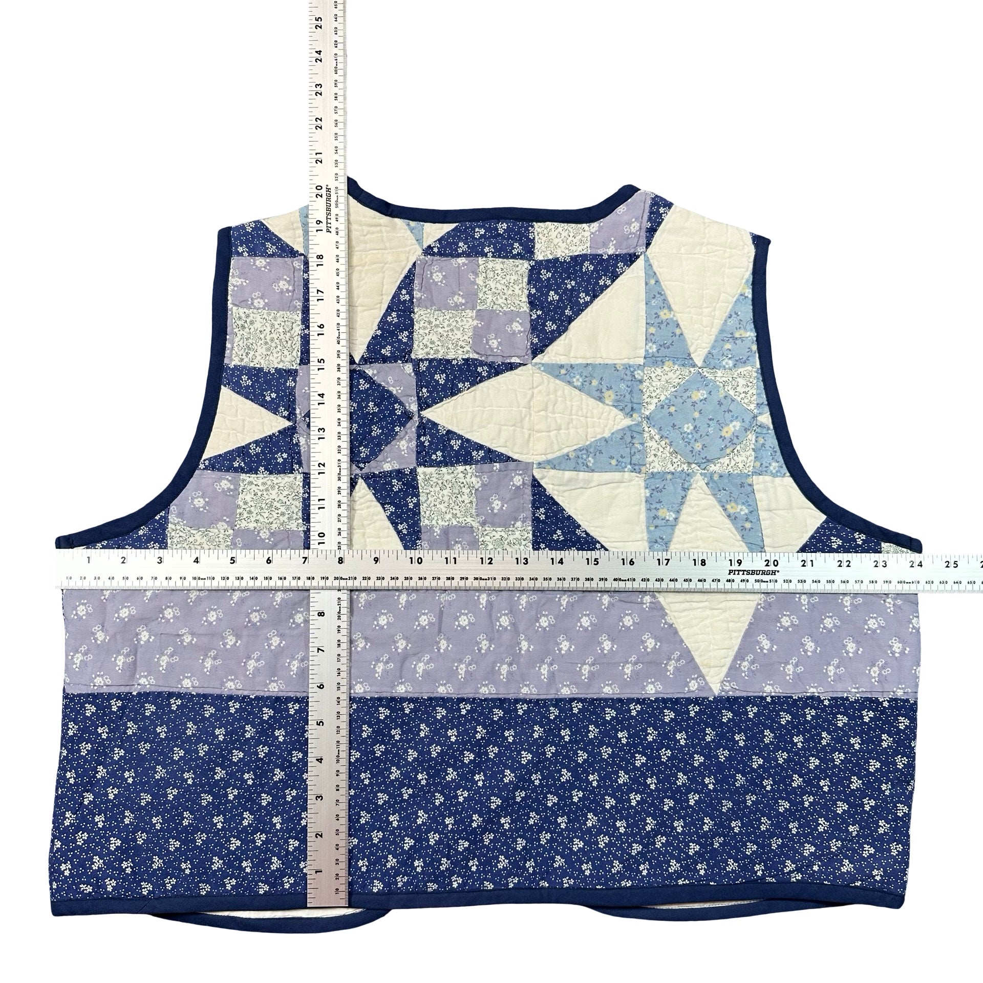 Periwinkle Pinwheel XL quilted vest rework, tape measure across the chest